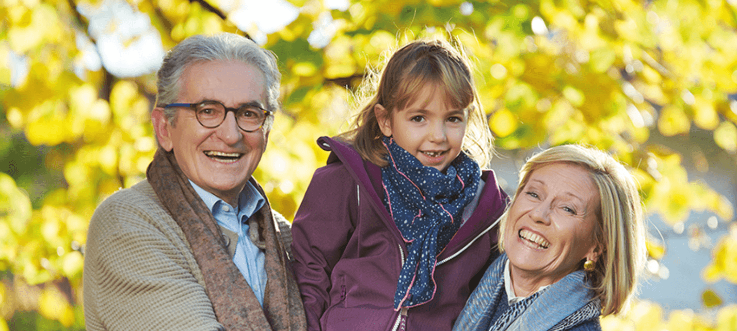 Photo de famille heureuse avec une enfant au milieu et ses grands parents